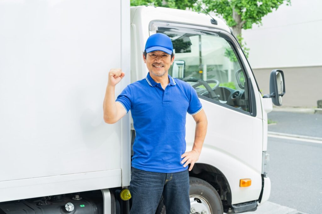 ガッツポーズをしている男性配達員
