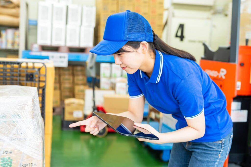 荷物を検品している作業服の女性